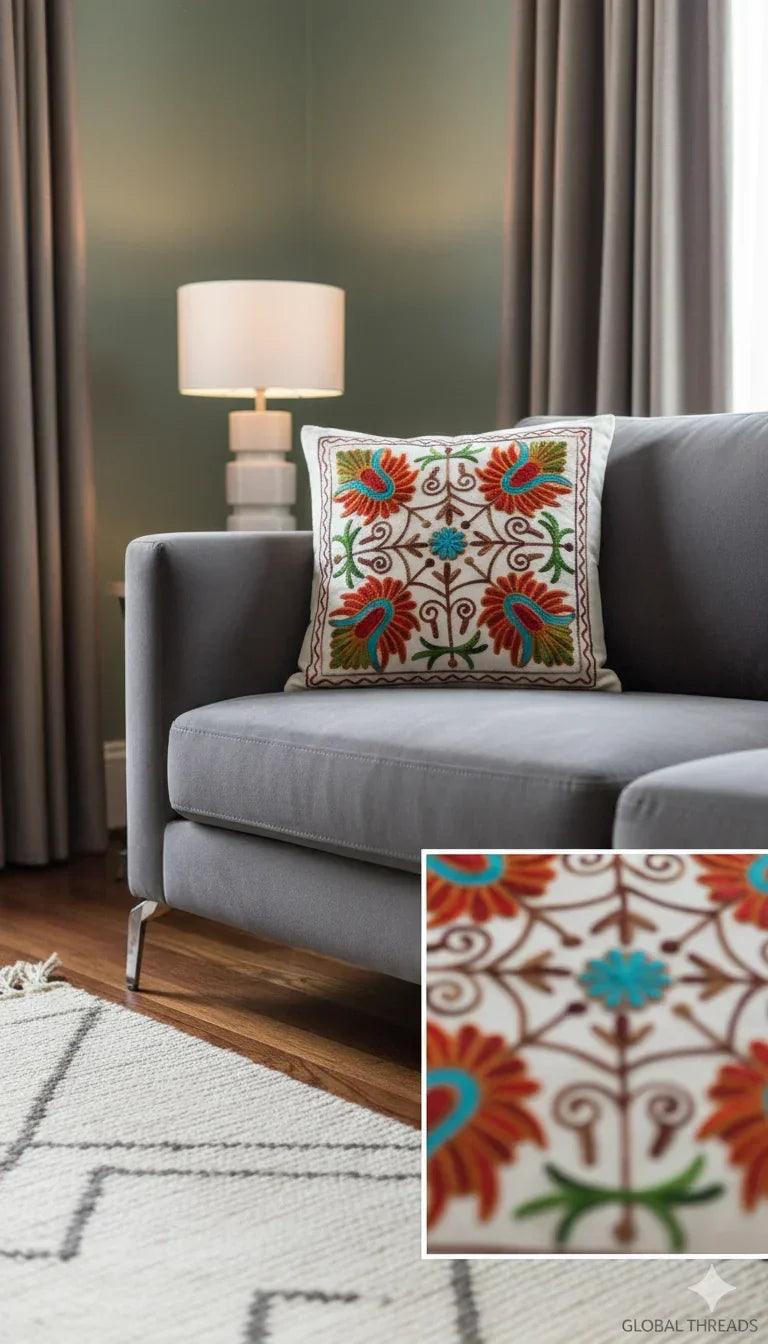 Boho embroidered throw pillow with floral pattern on gray sofa, cozy living room decor