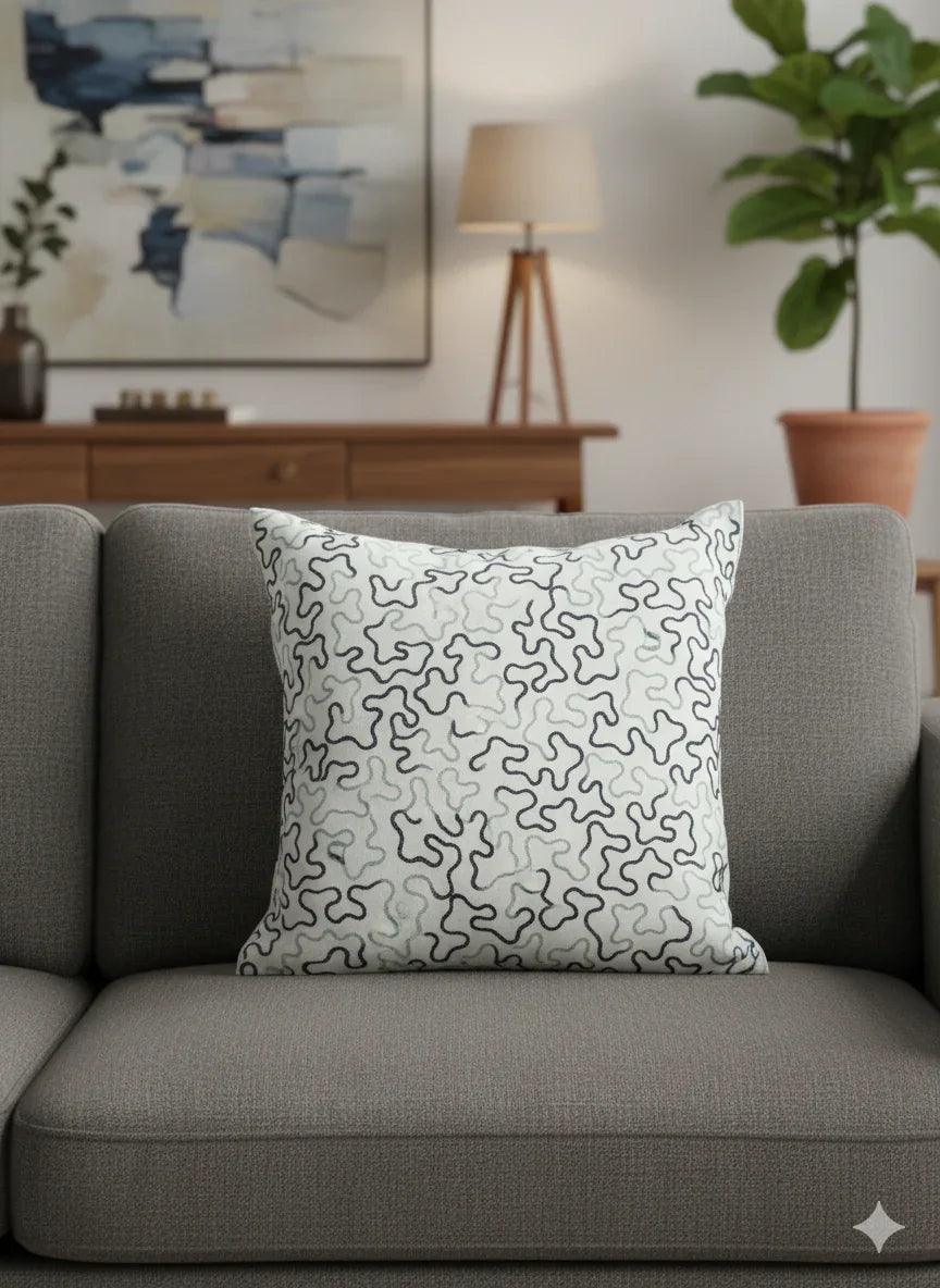 Abstract patterned throw pillow on gray sofa, modern living room decor with art and plant