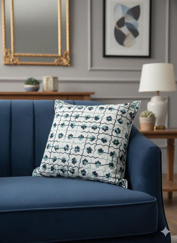 Floral patterned throw pillow on navy blue sofa in modern living room decor