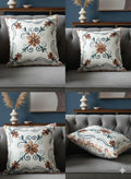 Floral embroidered throw pillow with orange and blue vines on gray sofa, home decor accent