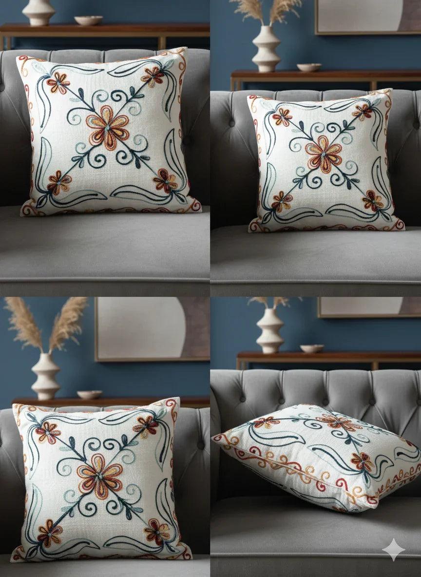 Floral embroidered throw pillow with orange and blue vines on gray sofa, home decor accent