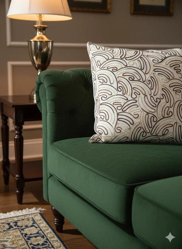Green tufted sofa with patterned throw pillow, side table, and lamp in cozy living room