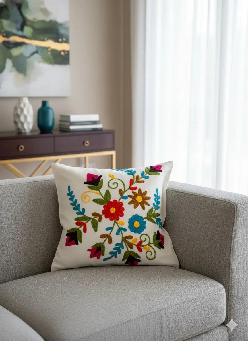 Colorful floral embroidered throw pillow on gray sofa, boho home decor accent