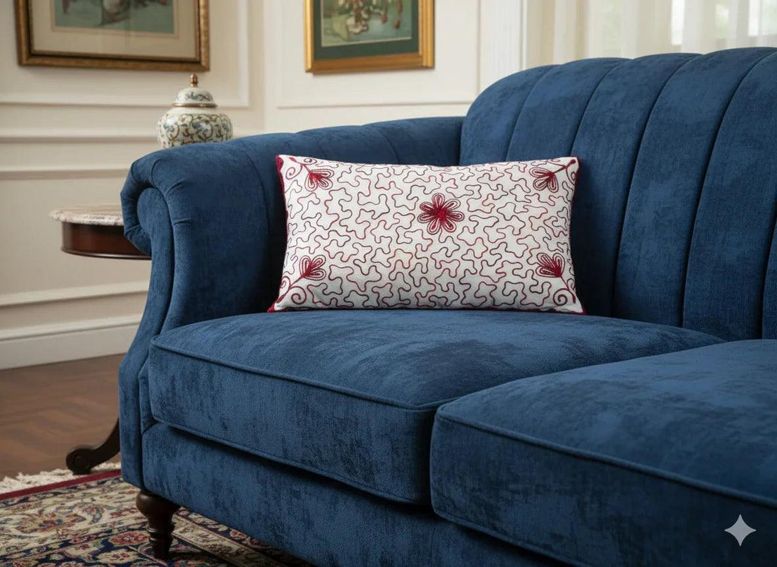 Blue velvet sofa with red floral patterned throw pillow in elegant living room