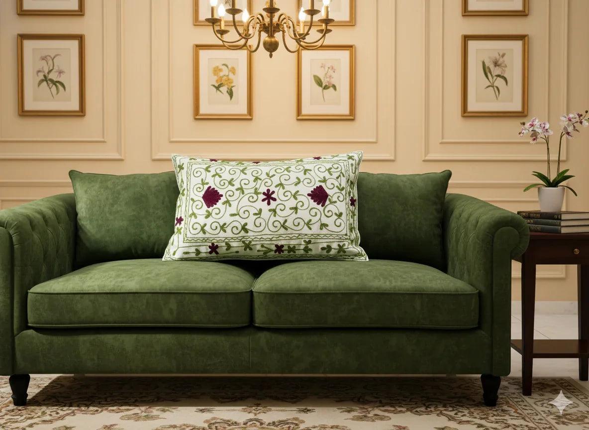 Green velvet sofa with floral embroidered pillow in elegant living room decor