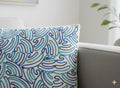 Blue wave pattern embroidered throw pillow on gray sofa, coastal home decor accent